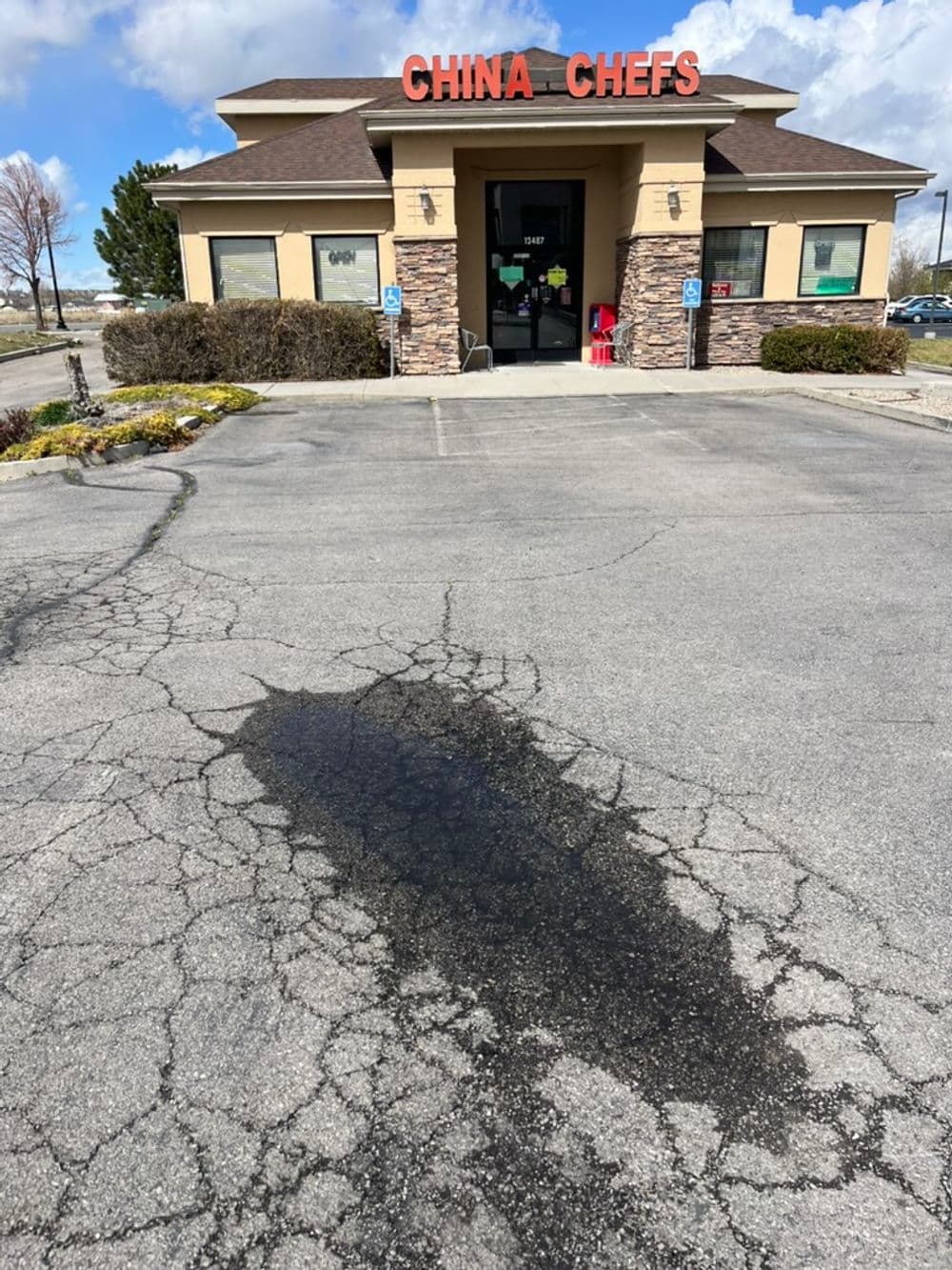 China Chefs restaurant exterior with cracked pavement and blue sky, located in a commercial area.