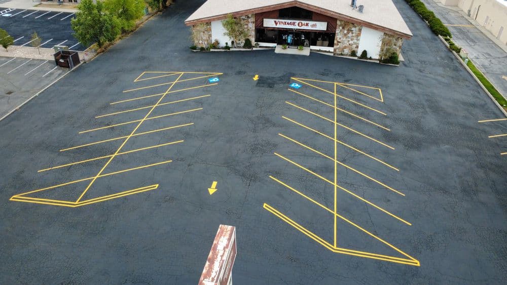 Aerial view of a large parking lot with yellow-striped spaces at Vintage Oak restaurant.