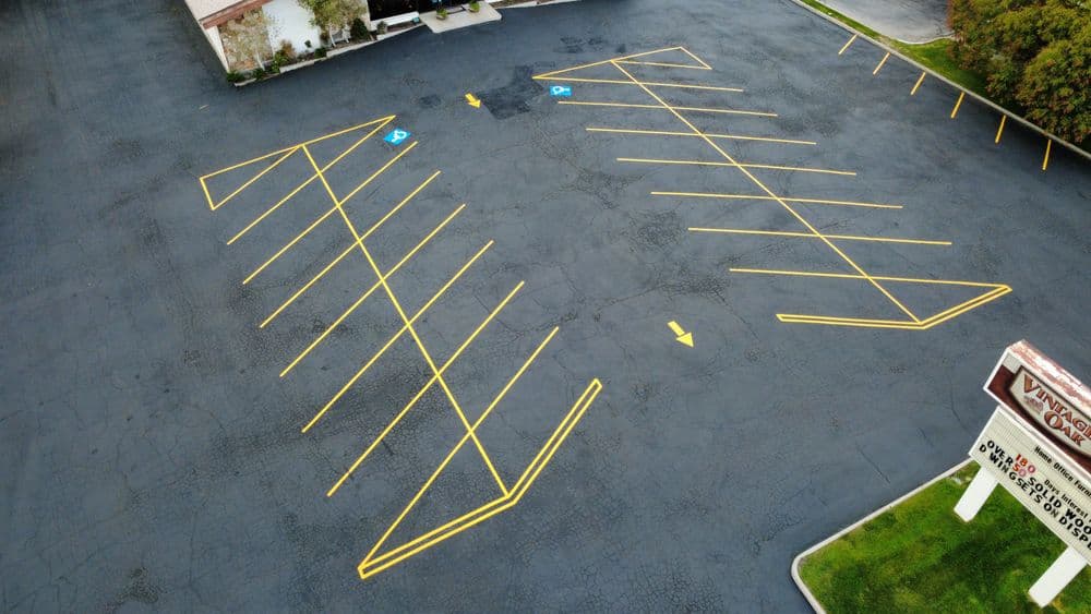 Aerial view of a spacious parking lot with marked handicapped spaces and yellow lines.