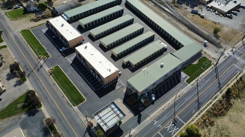 Aerial view of a storage facility with multiple units and a parking area.